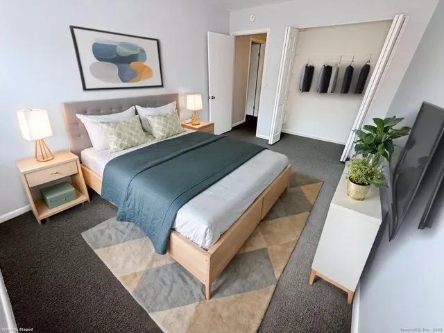 a bedroom with bed and painting on the wall