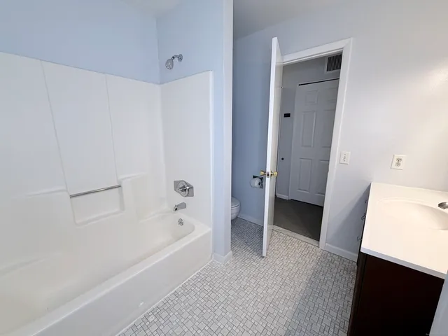 a bathroom with a tub shower and a sink