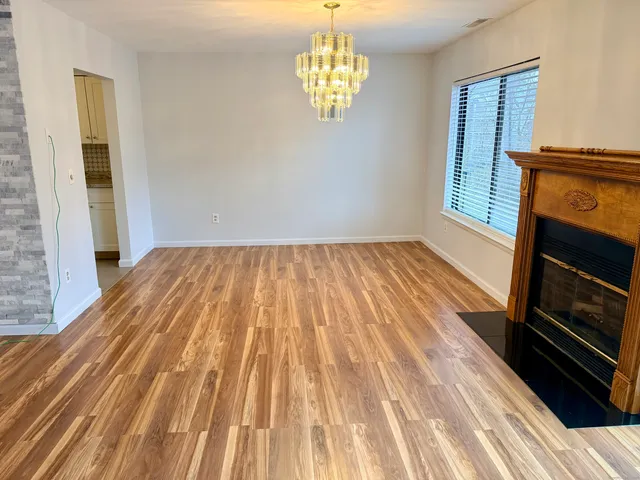 a view of empty room with wooden floor and fireplace