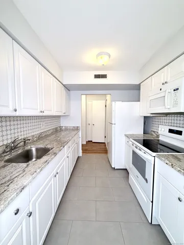 a large kitchen with a stove and a sink