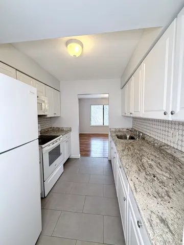 a kitchen with granite countertop a sink stainless steel appliances and cabinets