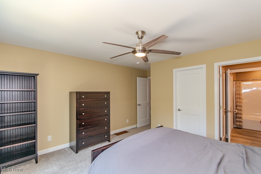 8675 Auburn Road Chardon, OH 44024 - Photo 26 of 35 Bedroom with light colored carpet, a ceiling fan, and ensuite bathroom