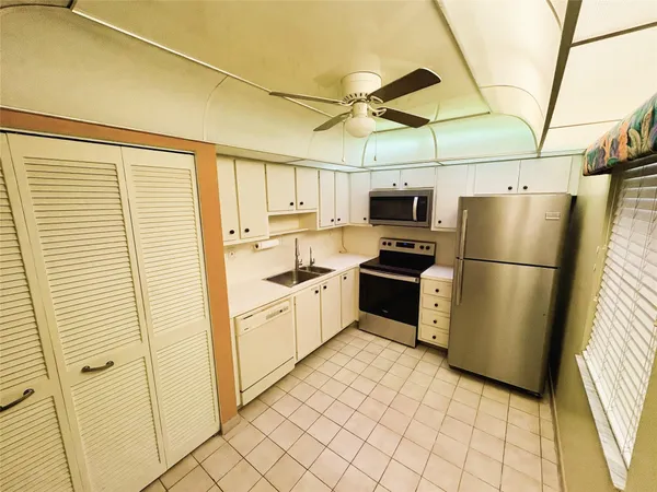 a kitchen with stainless steel appliances a refrigerator sink and cabinets