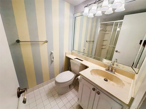 a bathroom with a sink toilet mirror and vanity