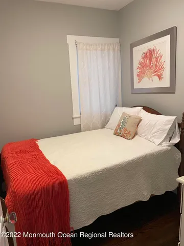 a bedroom with a bed and painting on the wall