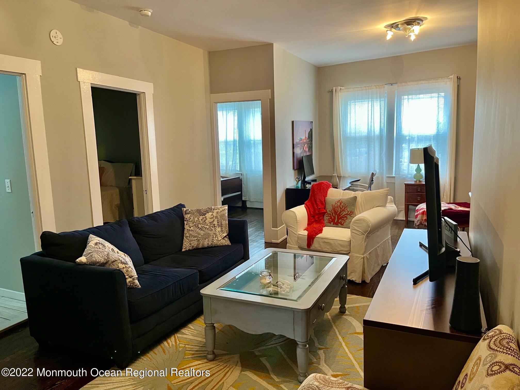 216 Main Street, Unit UP Avon-by-the-Sea, NJ 07717 - Photo 7 of 20 a living room with furniture and a wooden floor