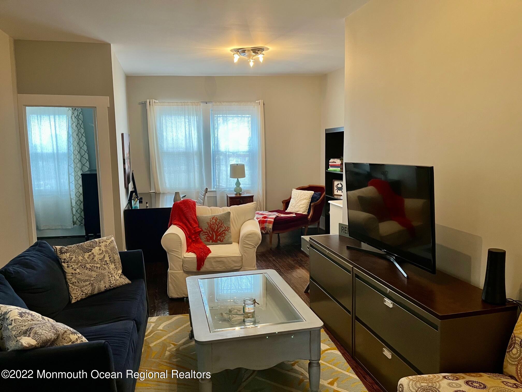 216 Main Street, Unit UP Avon-by-the-Sea, NJ 07717 - Photo 8 of 20 a living room with furniture and a flat screen tv