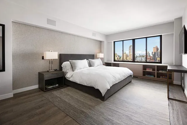 a bedroom with a bed and a large window