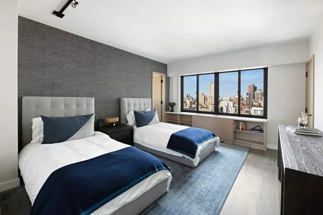 a bedroom with two beds and a large window