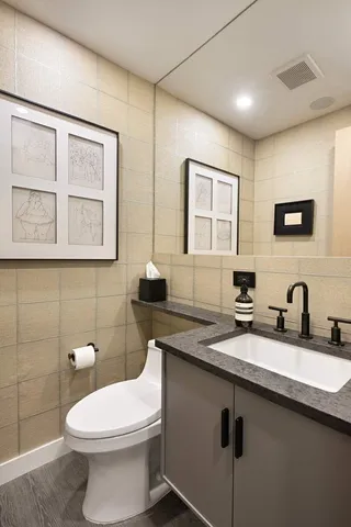a bathroom with a granite countertop toilet sink and mirror