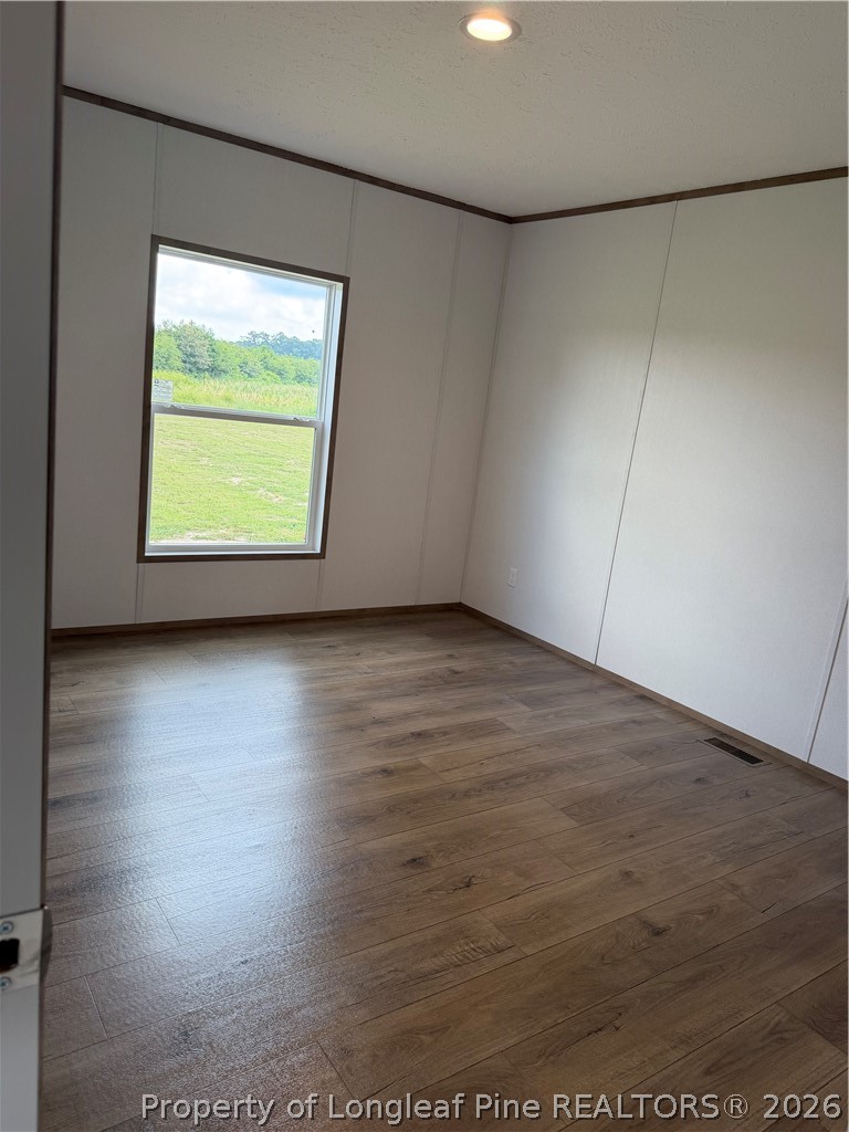 866 Roberta Road Fairmont, NC 28340 - Photo 14 of 16 an empty room with wooden floor and windows