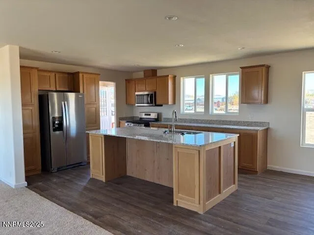 a kitchen with stainless steel appliances granite countertop a sink stove and refrigerator