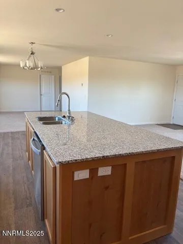 a kitchen with granite countertop cabinets and chandelier