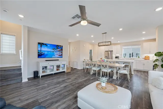 a living room with furniture a dining table wooden floor and a fireplace