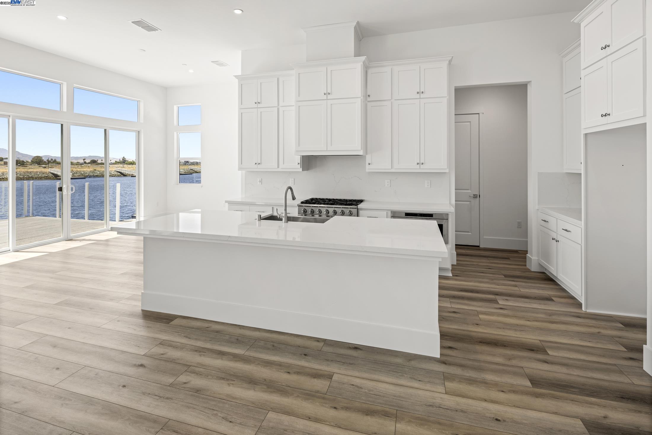 6008 Windsweep Road Bethel Island, CA 94511 - Photo 10 of 21 a white kitchen with cabinets and wooden floor