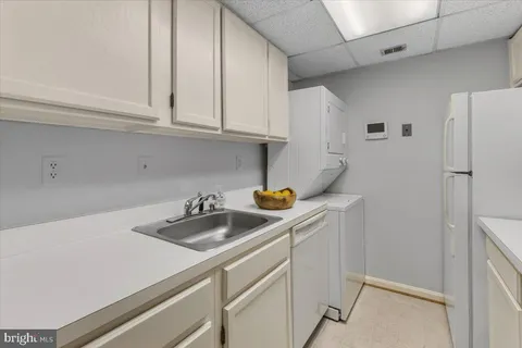 a kitchen with stainless steel appliances a sink a refrigerator and cabinets