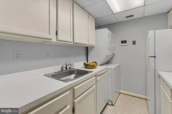 a kitchen with stainless steel appliances a sink a refrigerator and cabinets