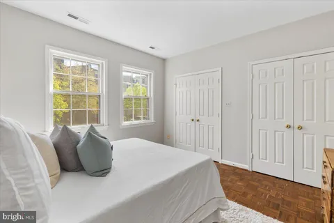 a large bed sitting in a bedroom next to a window