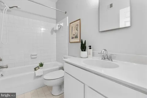 a bathroom with a granite countertop sink a toilet and shower