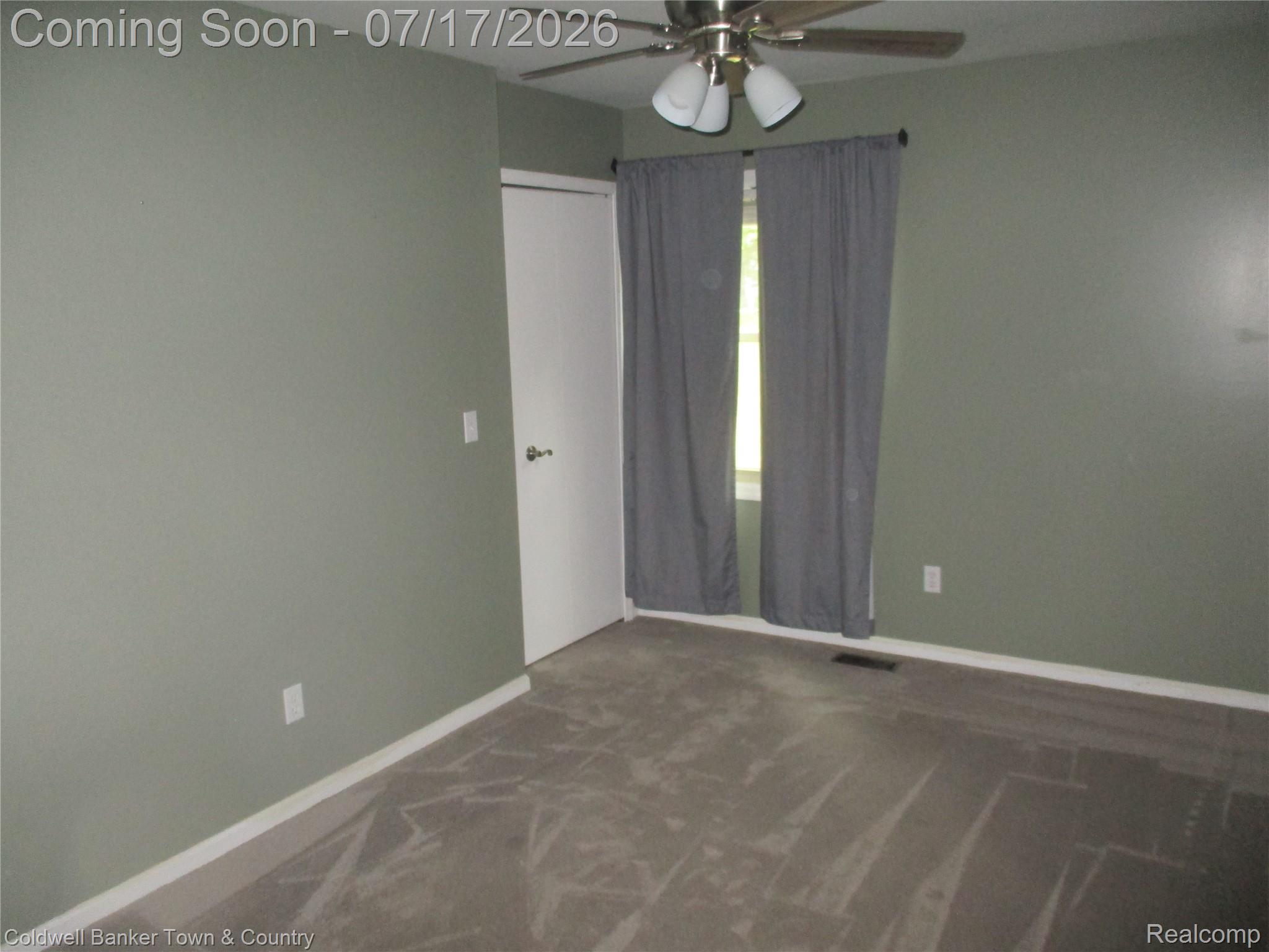 1996 Triangle Lake Road Howell, MI 48843 - Photo 11 of 32 Bedroom 1 featuring a window with privacy drapes, a ceiling fan with light fixture, light green wall paint, and carpeting