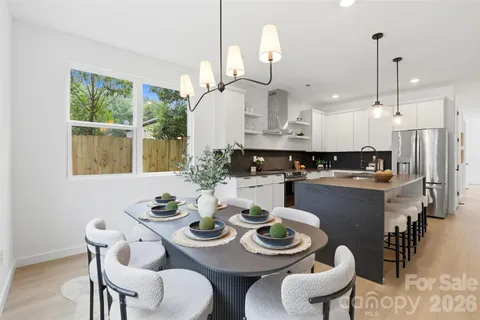 a dining room with furniture a chandelier and wooden floor