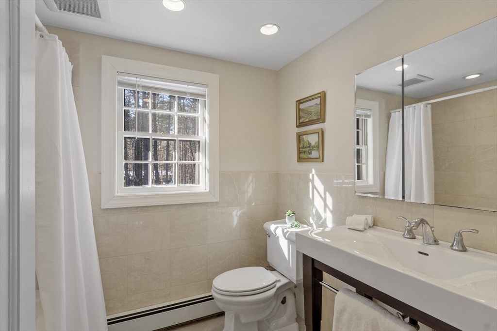 265 College Road Concord, MA 01742 - Photo 31 of 42 a bathroom with a sink a toilet a mirror and a window