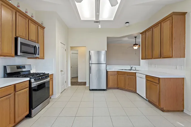 a kitchen with a refrigerator a stove top oven a sink and dishwasher