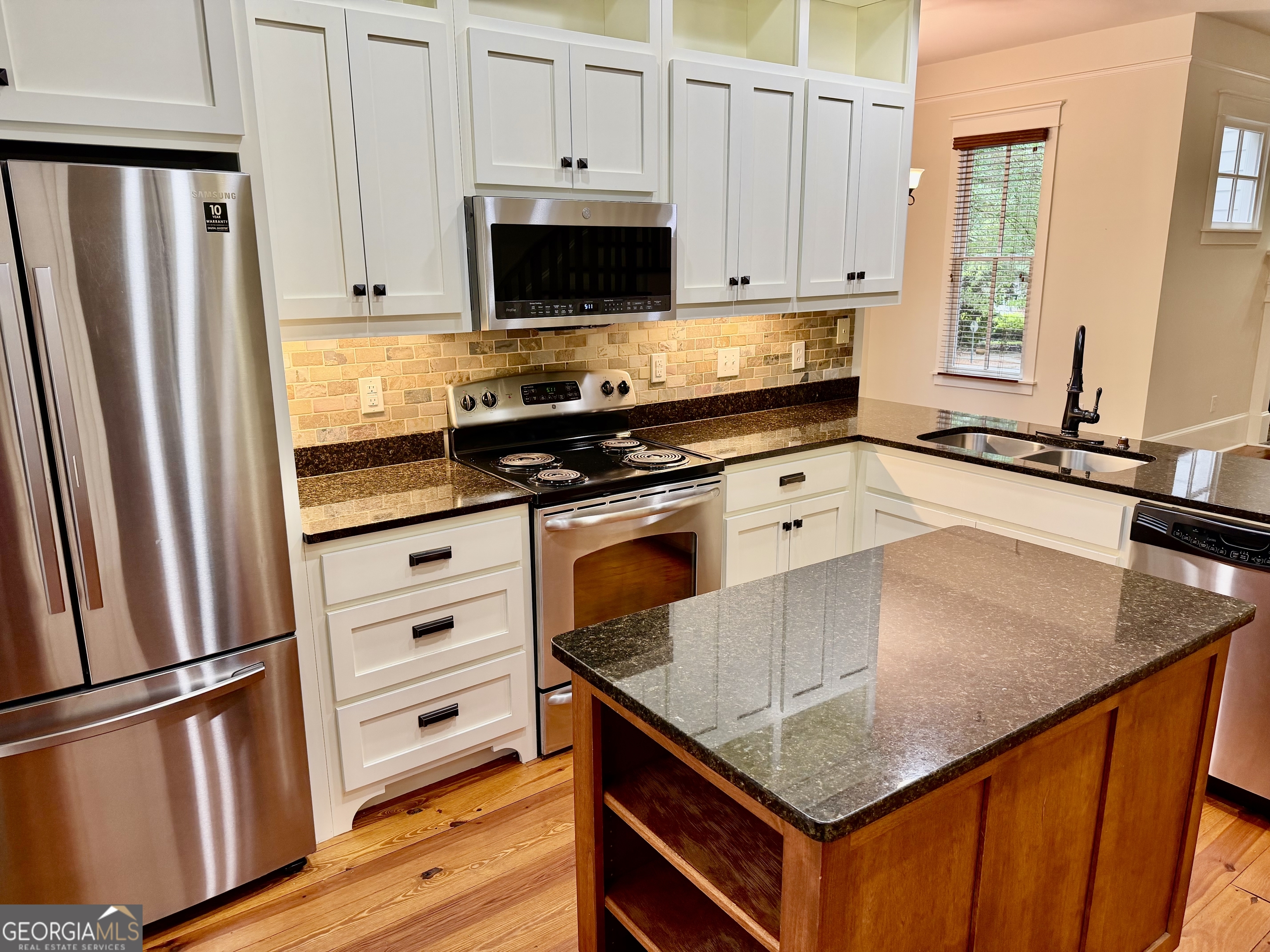 25 Charter Oak Drive Athens, GA 30607 - Photo 11 of 19 a kitchen with stainless steel appliances granite countertop a refrigerator a stove and a sink with wooden floor