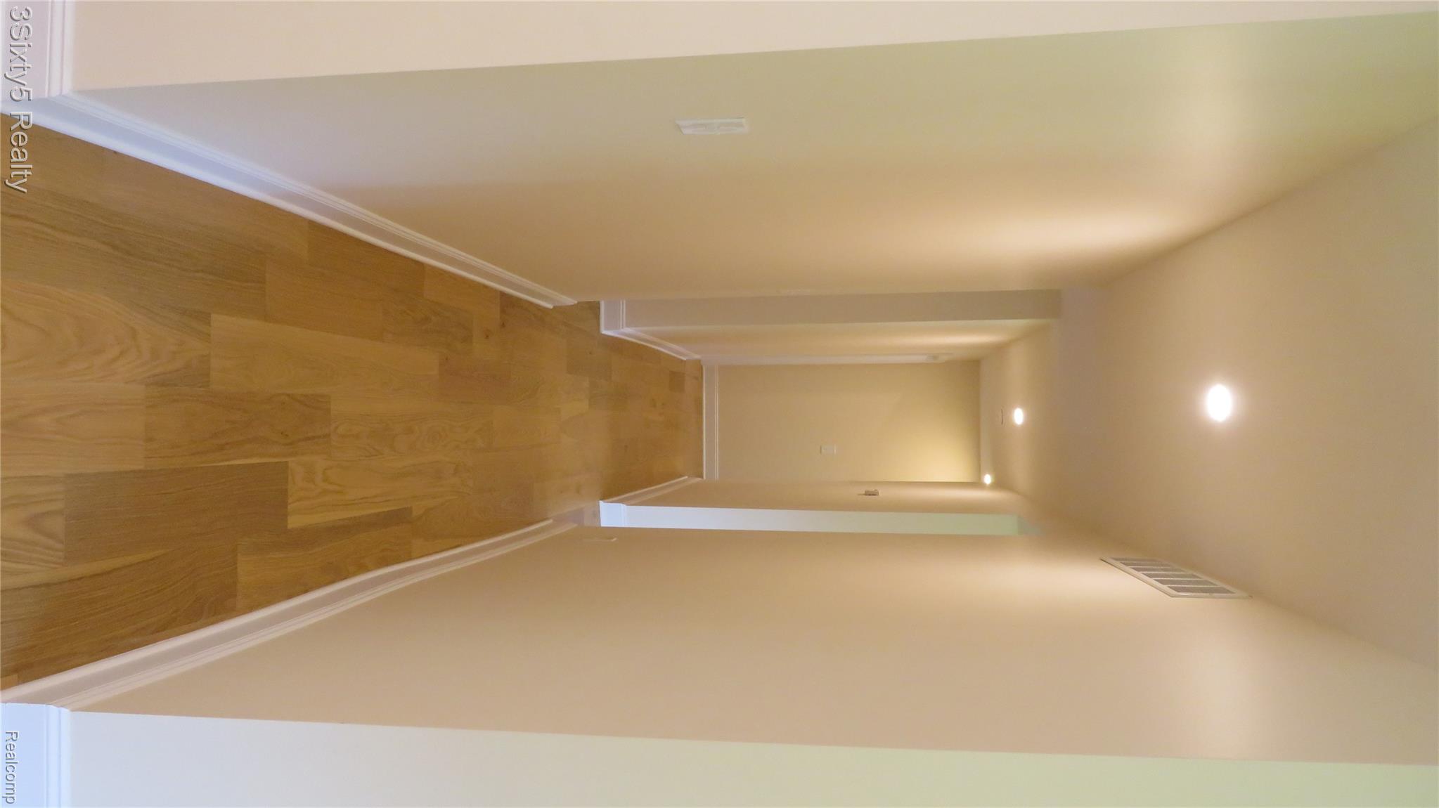 16558 Haggerty Road Belleville, MI 48111 - Photo 10 of 40 Recessed lighting illuminates a hallway with wood-finish flooring and light-toned walls