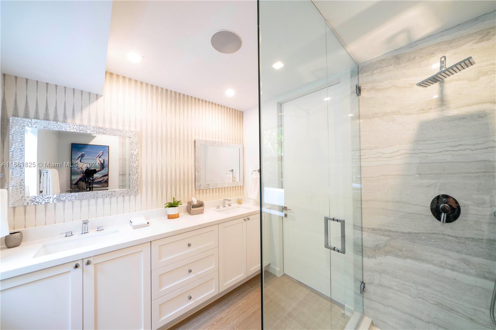 5334 Pine Tree Drive Miami Beach, FL 33140 - Photo 16 of 42 a bathroom with a double vanity sink a mirror and shower