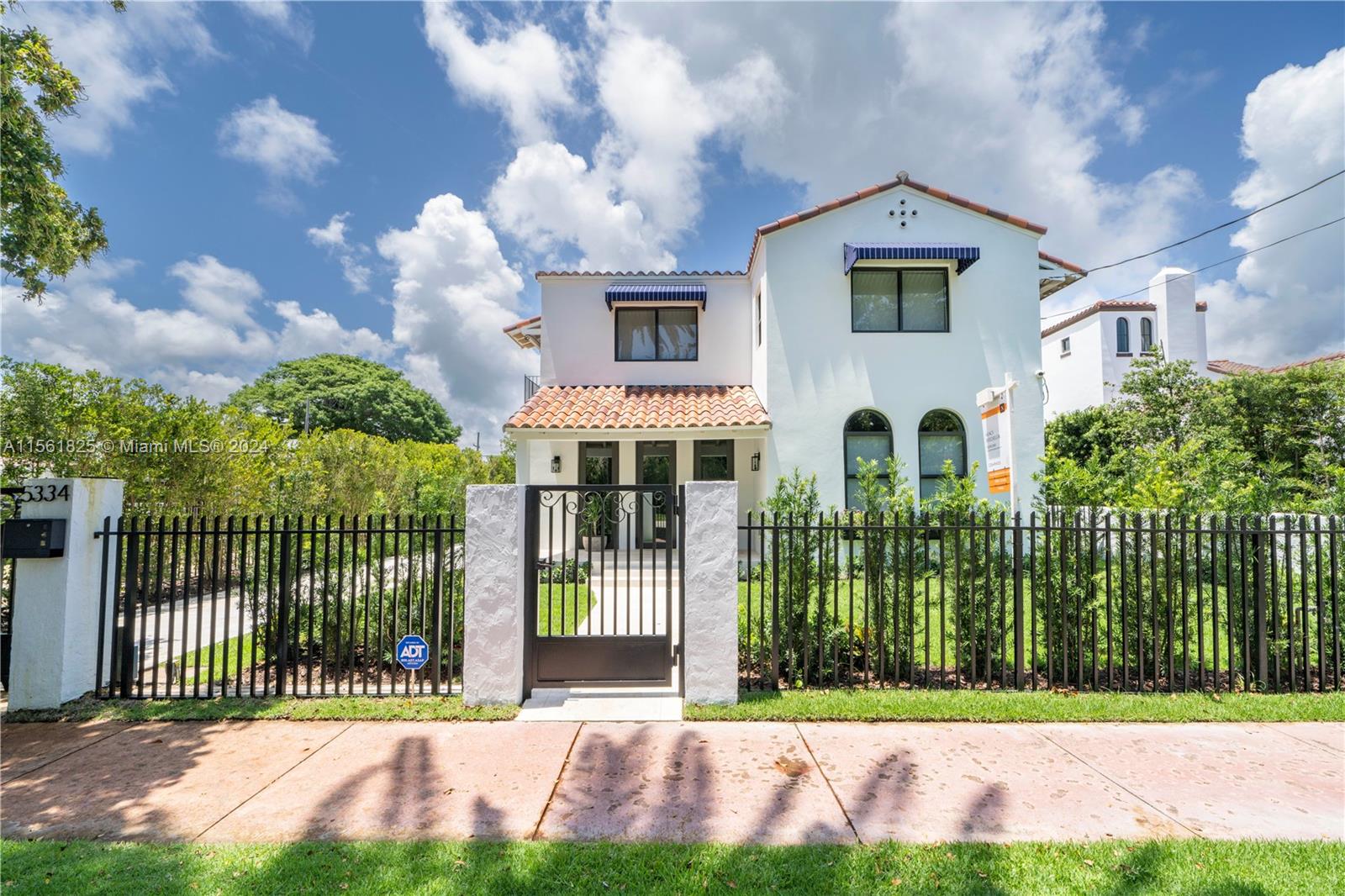5334 Pine Tree Drive Miami Beach, FL 33140 - Photo 34 of 42 a front view of a house with a garden and plants