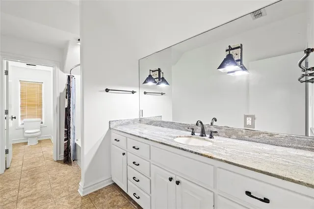 a bathroom with a granite countertop sink mirror and vanity