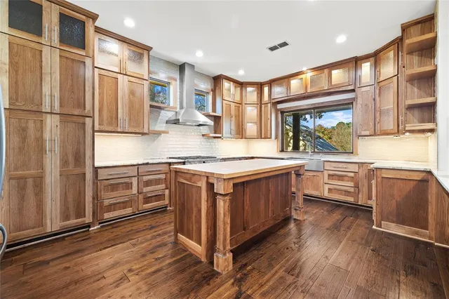 a kitchen with stainless steel appliances granite countertop a stove a sink dishwasher a refrigerator and cabinets with wooden floor