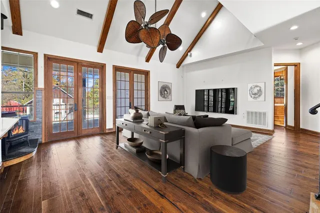 a living room with couches a dining table and chairs with wooden floor