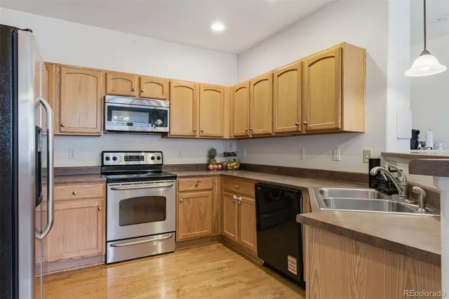 a kitchen with stainless steel appliances granite countertop a stove a sink and a microwave