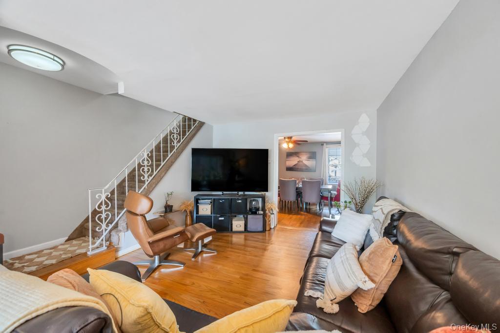 89-13 84th Street Queens, NY 11421 - Photo 12 of 34 Hardwood flooring throughout the main living space with light gray wall tones and white trim