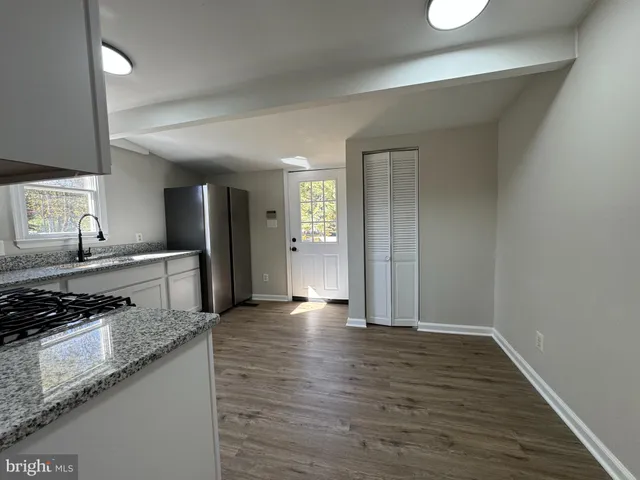 a kitchen with granite countertop a refrigerator stove top oven and sink