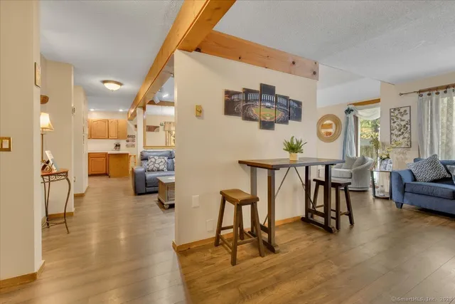 a living room with furniture and kitchen view with wooden floor