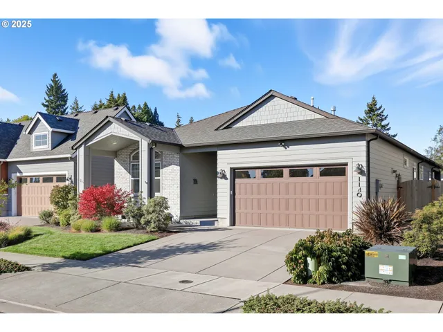 a front view of a house with a yard and potted plants