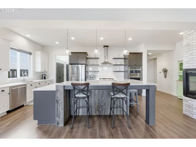 a dining room with wooden floor a chandelier a wooden table and chairs