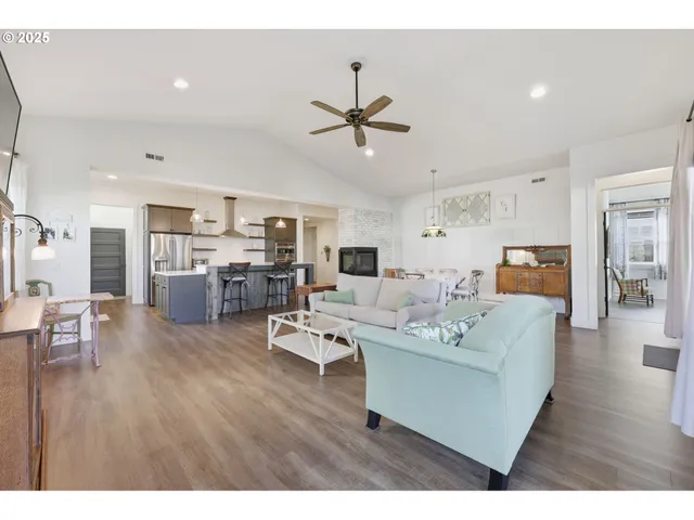 a living room with furniture a flat screen tv and kitchen view