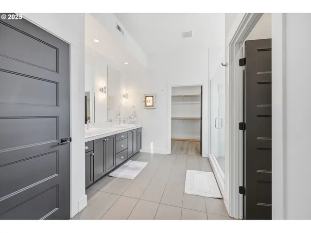 a bathroom with a double vanity sink a mirror and a shower