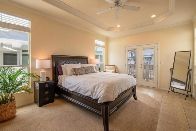 a spacious bedroom with a bed a couch and a potted plant on the dresser