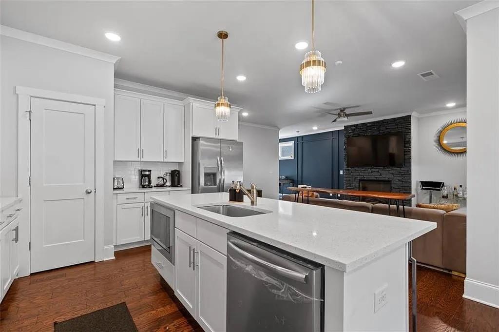 813 Coleman Street Southwest Atlanta, GA 30310 - Photo 18 of 39 a kitchen with stainless steel appliances a sink a stove a microwave a center island and cabinets