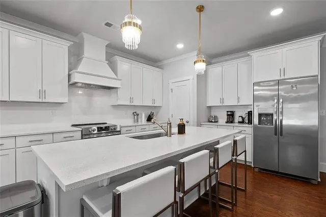 a kitchen that has a lot of cabinets in it wooden floors and white appliances