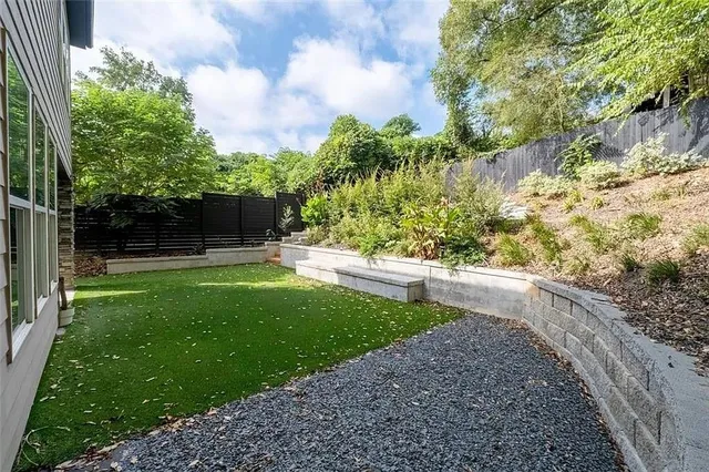 a view of backyard with potted plants and a large tree