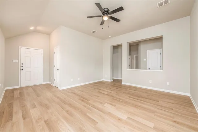 a view of empty room with wooden floor