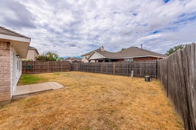 a view of yard with swimming pool and wooden fence