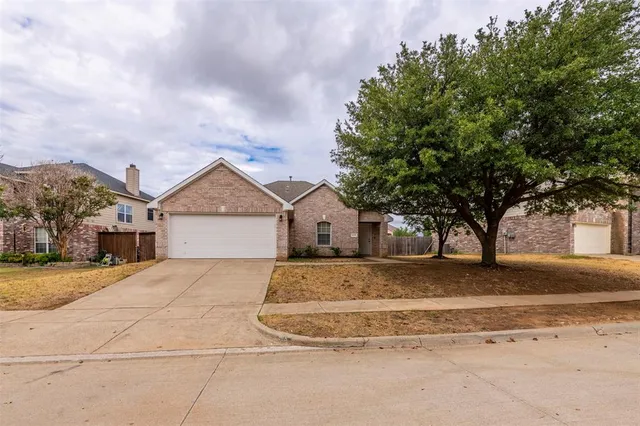 a view of white house with a big yard and large trees