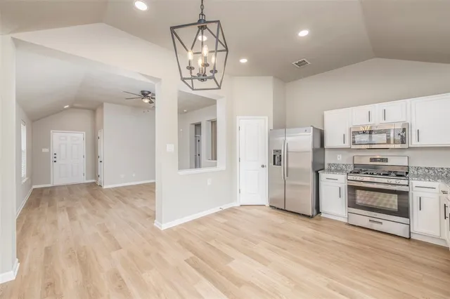 a view of a kitchen with a stove cabinets and wooden floor